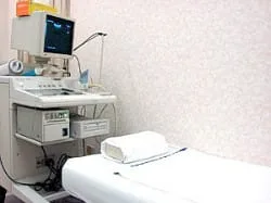 受付カウンターと待合へ続く院内導線、明るい照明のある受付前